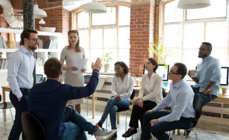 Male worker raise hand asking question at office teambuilding