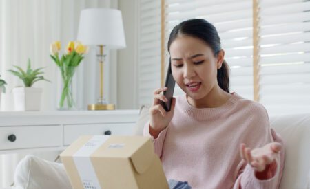 Woman talking on phone while looking at a package