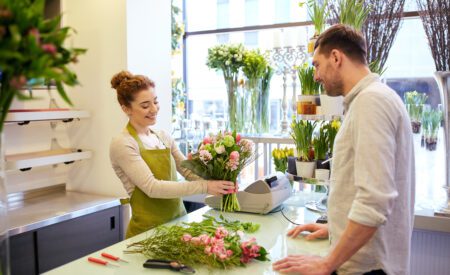 Man buying a bouquet of flowers from a woman florist