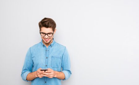 Man with glasses looking at his phone
